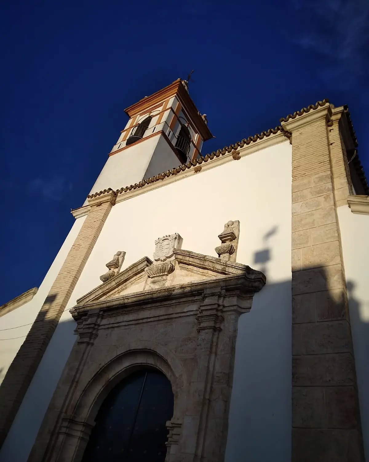 Fachada de una de las iglesias de La Roda de Andalucía, destacándose bajo un cielo azul despejado.