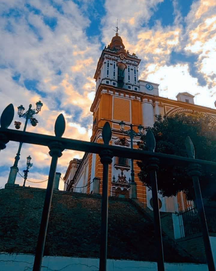 Iglesia de San Juan Bautista en Las Cabezas de San Juan iluminada por los cálidos tonos del atardecer.